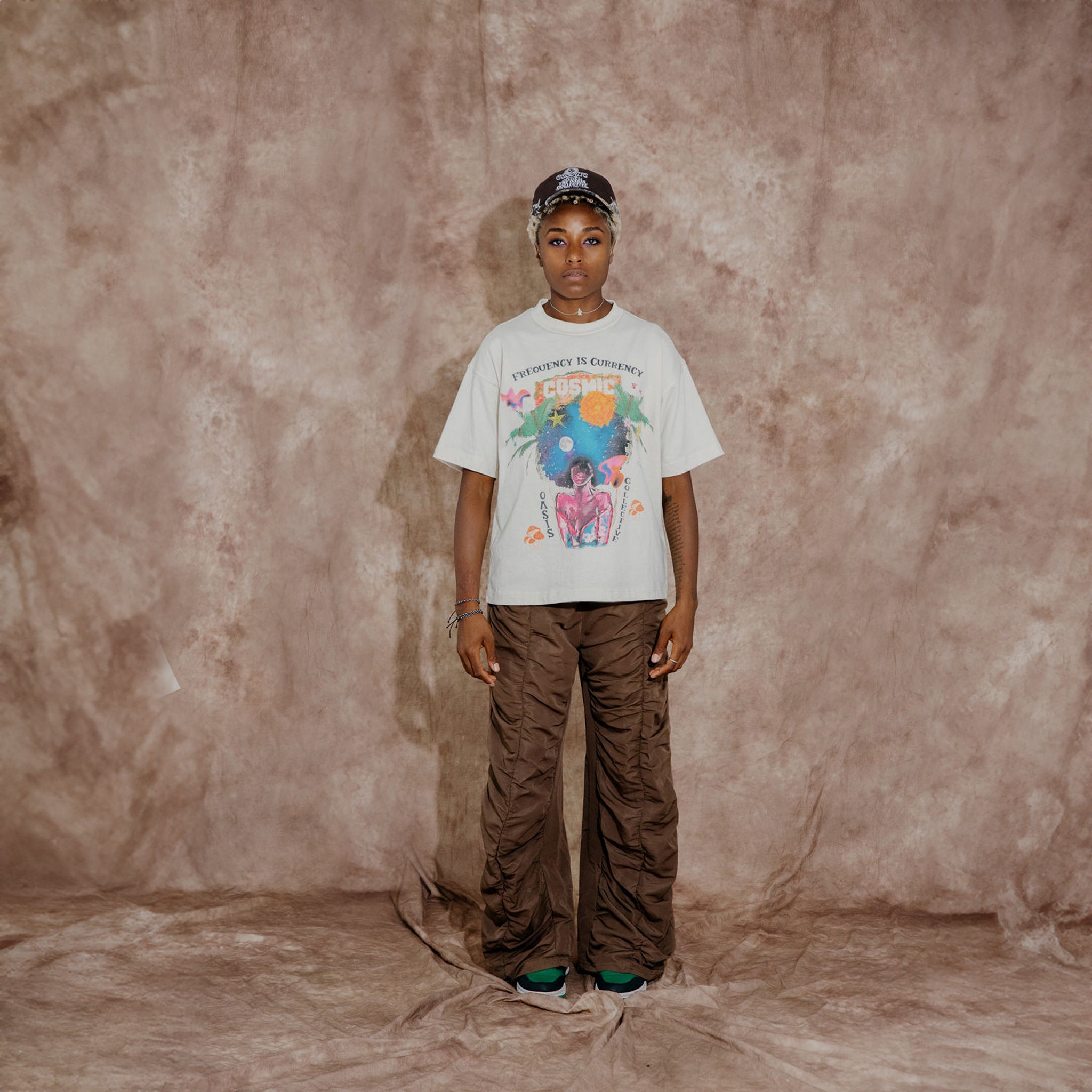 Cosmic the Oasis offers a 100% cotton t-shirt with printed Miami Pop Up graphics on front and back, available in black and champagne. Standard sizing. All cotton tees should always be washed in cold water, with delicate or line dry.