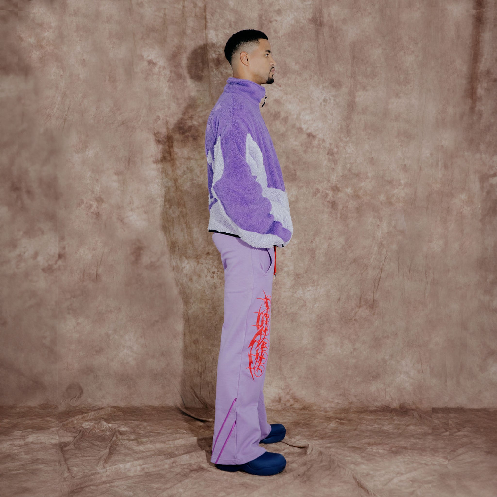 Cosmic the Oasis three-color purple sherpa zip up with extended sleeves can be worn as an oversized shirt layer or outerwear. Dramatic curved design with Cosmic logo across the back.