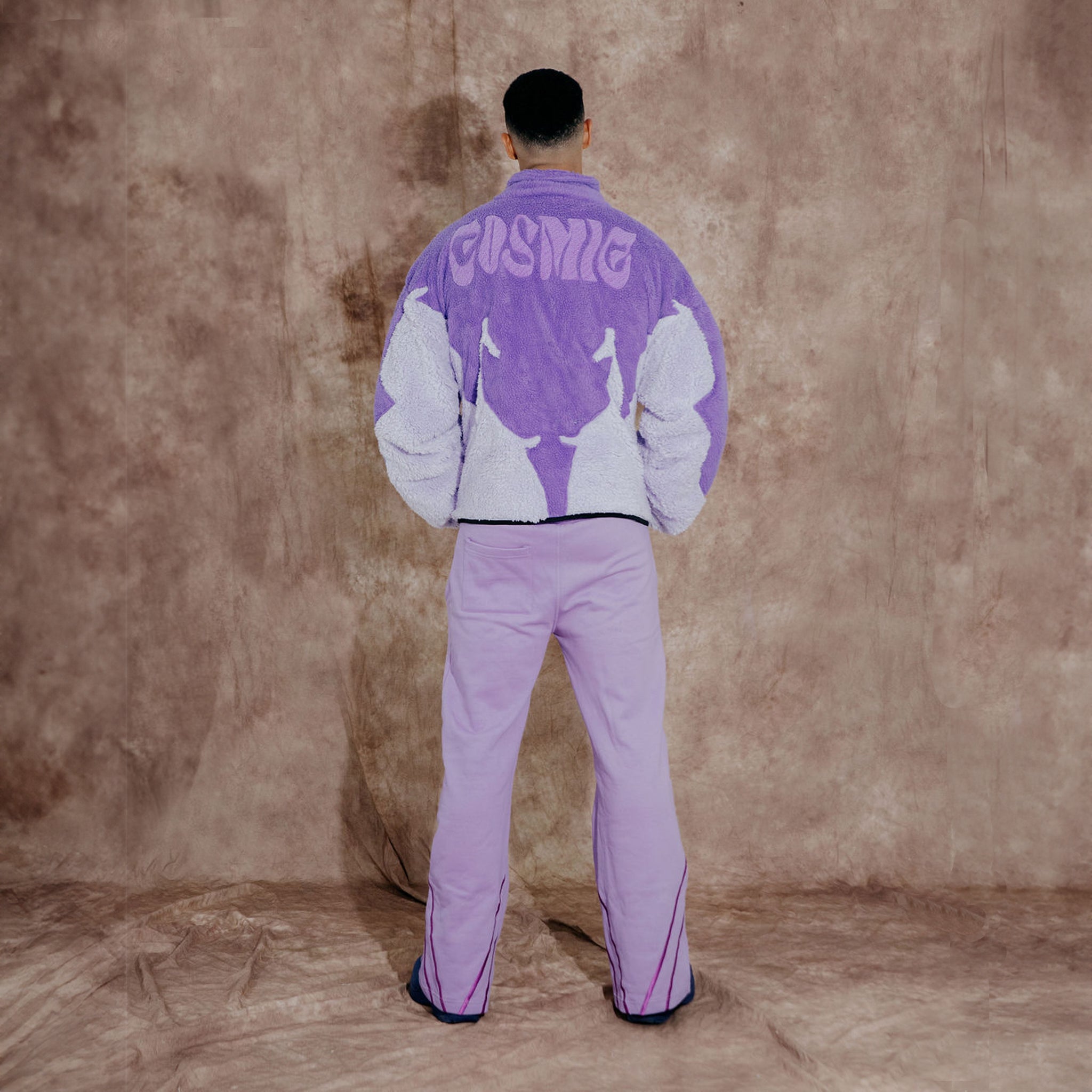 Cosmic the Oasis three-color purple sherpa zip up with extended sleeves can be worn as an oversized shirt layer or outerwear. Dramatic curved design with Cosmic logo across the back.