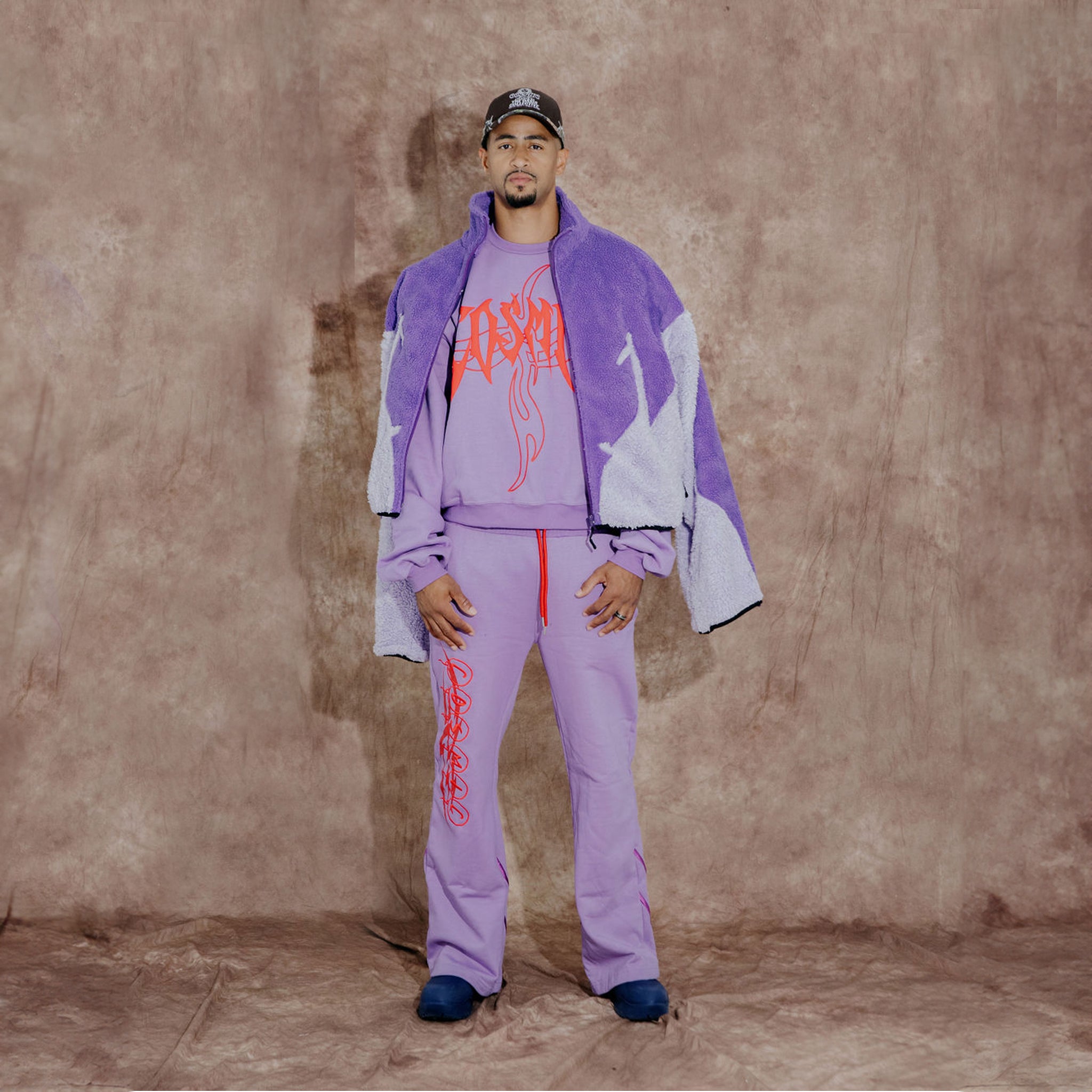 Cosmic the Oasis three-color purple sherpa zip up with extended sleeves can be worn as an oversized shirt layer or outerwear. Dramatic curved design with Cosmic logo across the back.