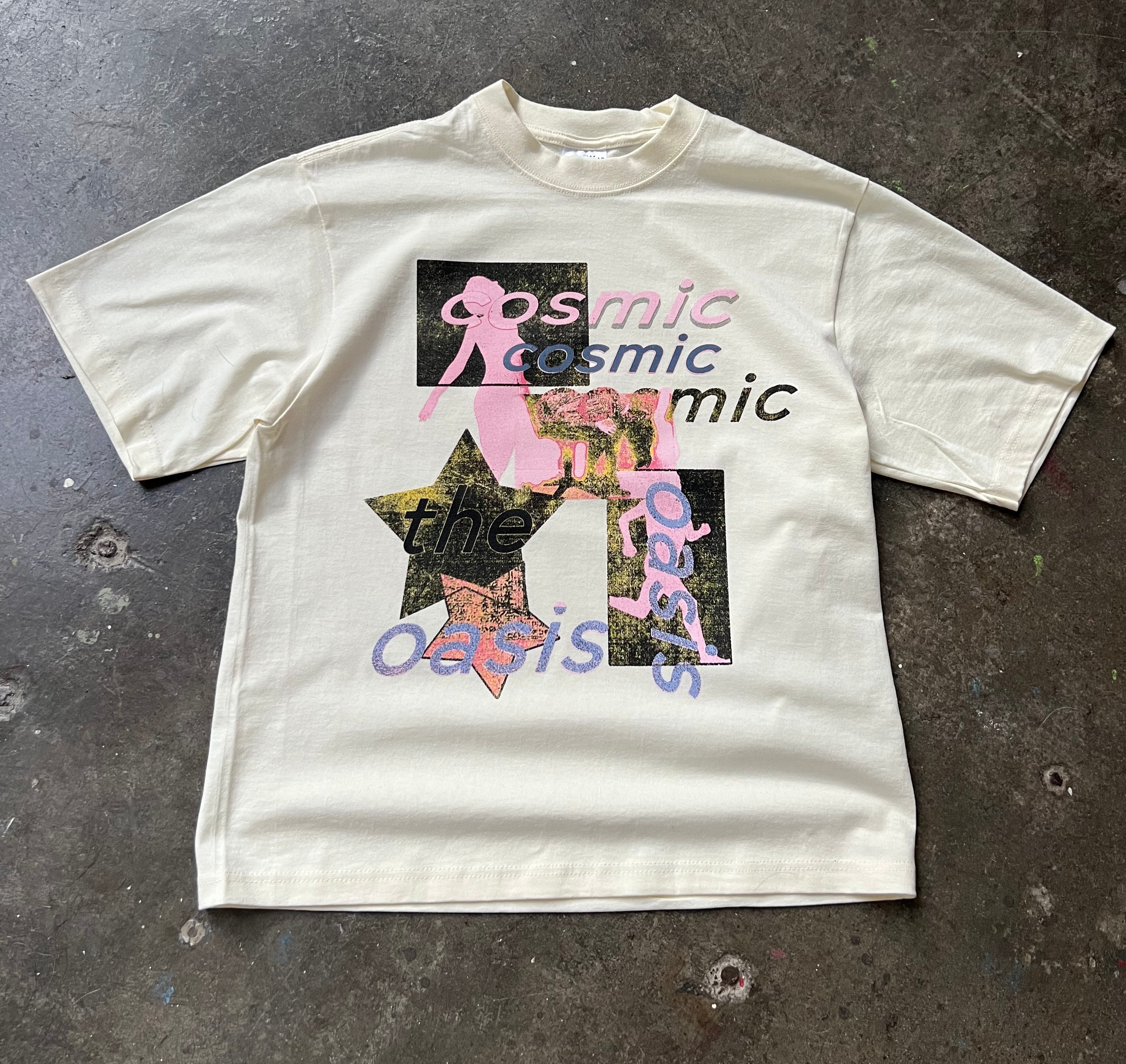 White t-shirt with graphic design and text on a dark surface