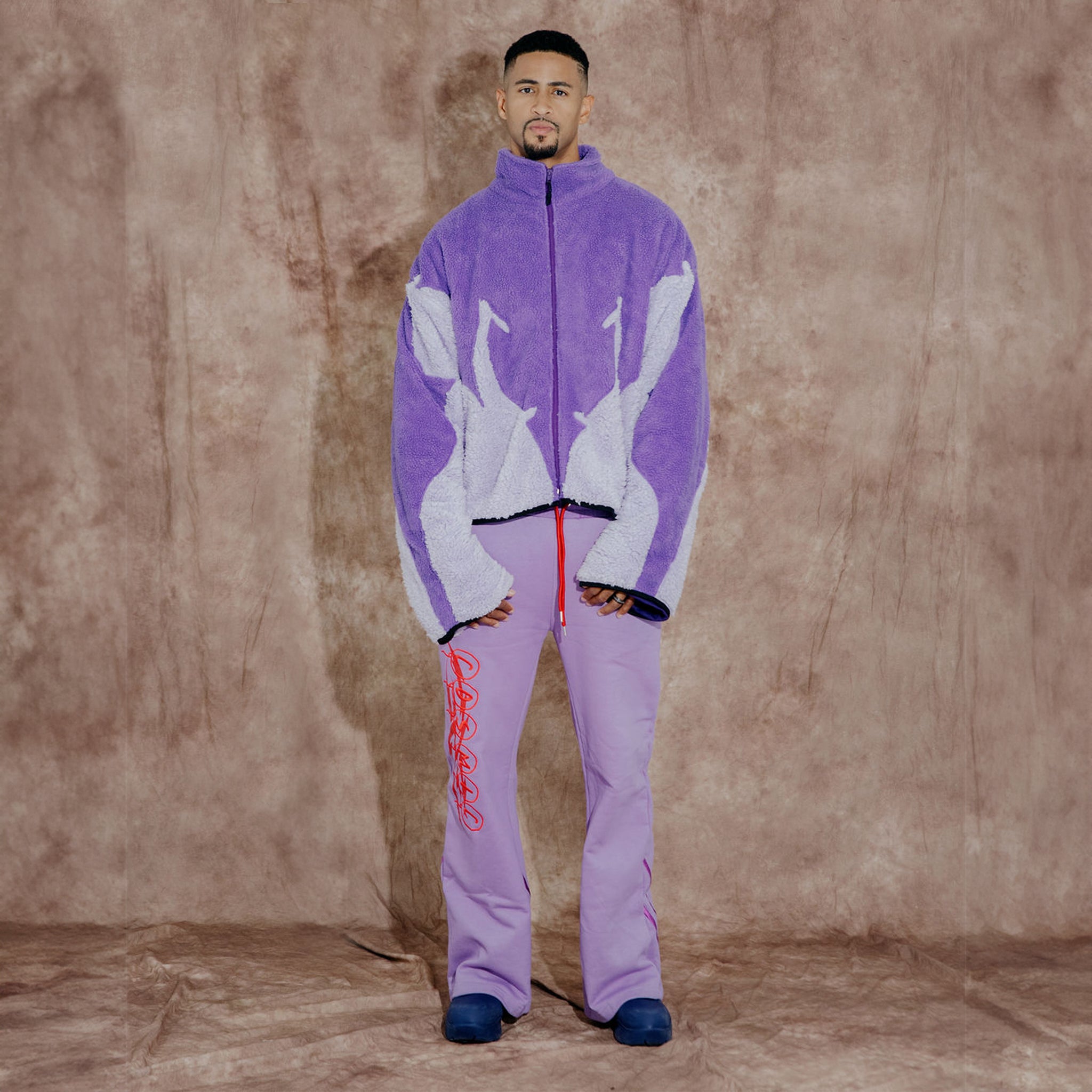 Cosmic the Oasis three-color purple sherpa zip up with extended sleeves can be worn as an oversized shirt layer or outerwear.  Dramatic curved design with Cosmic logo across the back.
